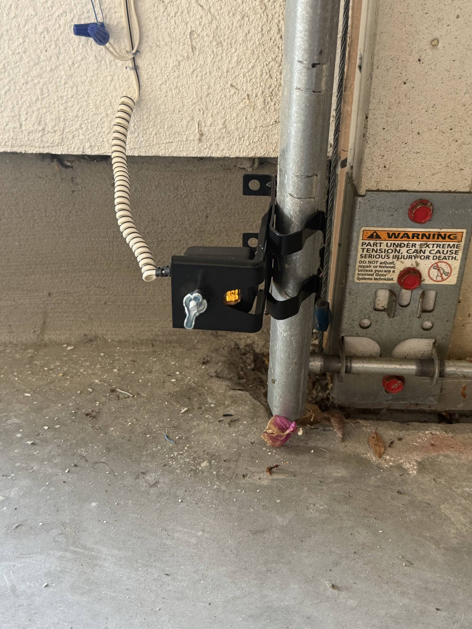 Garage door safety photo-eye sensor mounted on the track